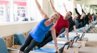 Pilates group poses on reformers