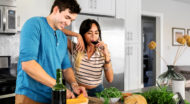 Couple cooking and drinking wine in the kitchen